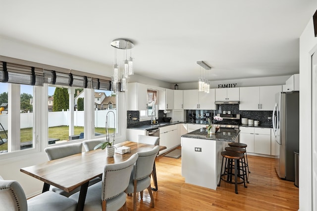 3705 Streamwood Dr, Hazel Crest, IL 60429 - kitchen featuring stainless steel appliances, decorative backsplash, under cabinet range hood, and a kitchen island