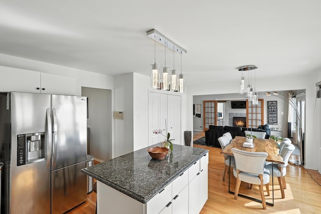 3705 Streamwood Dr, Hazel Crest, IL 60429 - kitchen featuring stainless steel refrigerator with ice dispenser, a warm lit fireplace, light wood-type flooring, and a center island