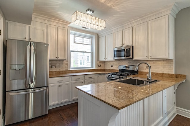 5952 N Paulina St Unit 2N, Chicago, IL 60660 - kitchen with appliances with stainless steel finishes, a peninsula, light stone countertops, dark wood-style flooring, and decorative backsplash