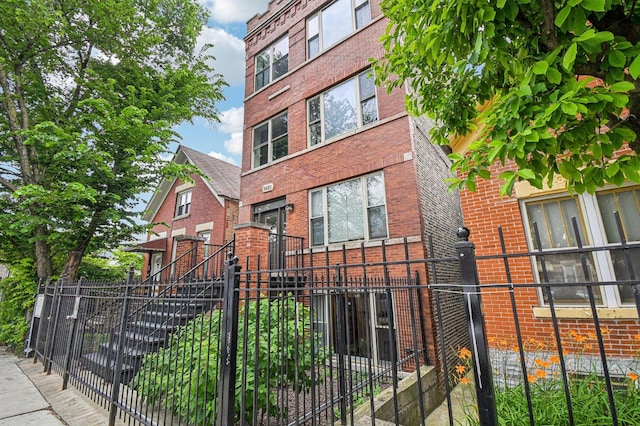 2423 W Augusta Blvd Unit 1, Chicago, IL 60622 - view of side of property with a fenced front yard and brick siding