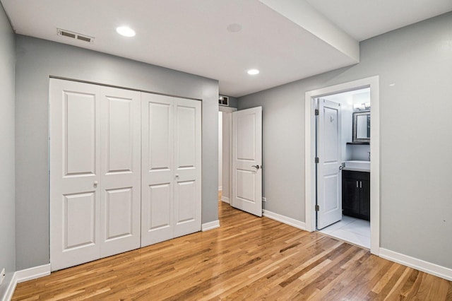 2423 W Augusta Blvd Unit 1, Chicago, IL 60622 - unfurnished bedroom featuring light wood-style flooring, connected bathroom, a closet, and recessed lighting
