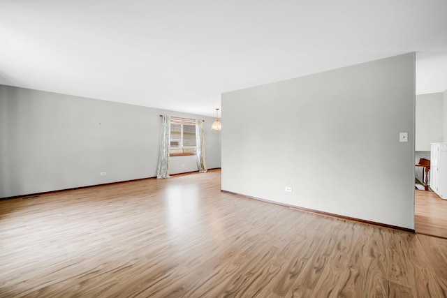 17720 Ashland Ave, Homewood, IL 60430 - empty room with light wood finished floors and a chandelier