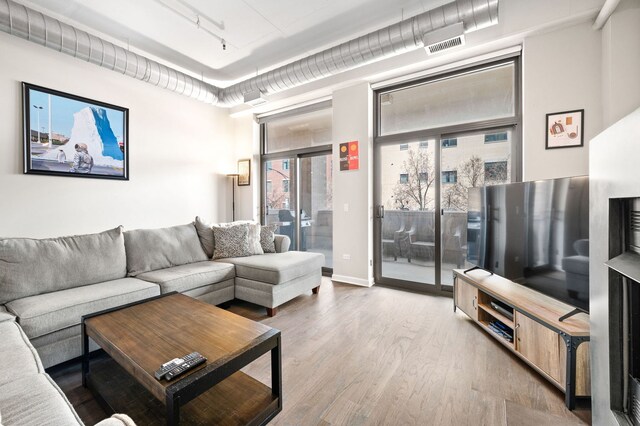 1301 W Madison St Unit 207, Chicago, IL 60607 - living area with wood finished floors and track lighting