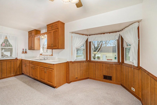17958 Escanaba Ave, Lansing, IL 60438 - kitchen with plenty of natural light, wooden walls, brown cabinets, light countertops, and wainscoting