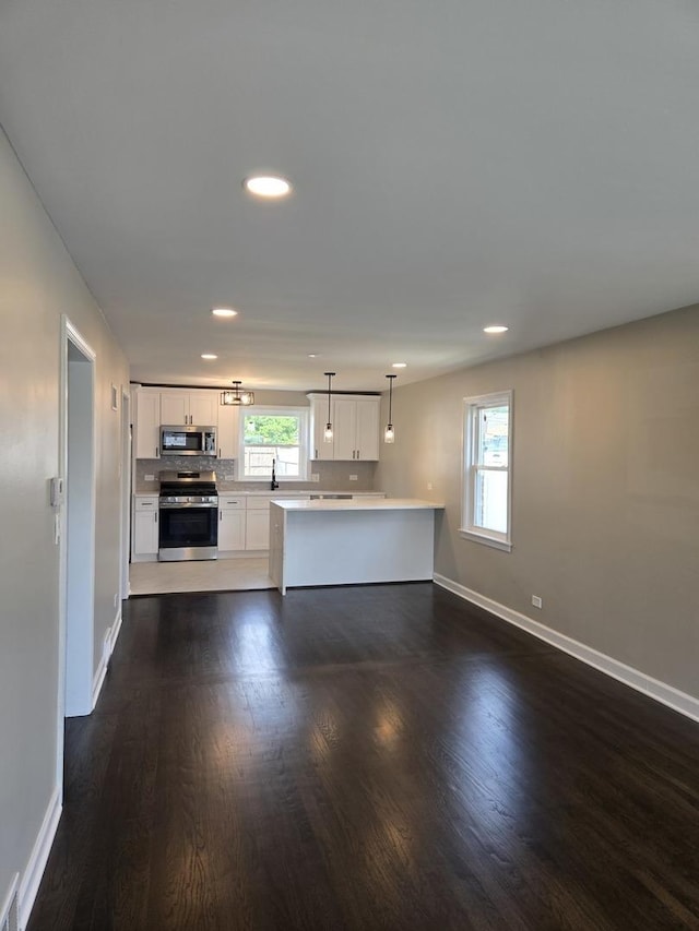 540 47th Ave, Bellwood, IL 60104 - kitchen with stainless steel appliances, dark wood-type flooring, a peninsula, white cabinets, and light countertops