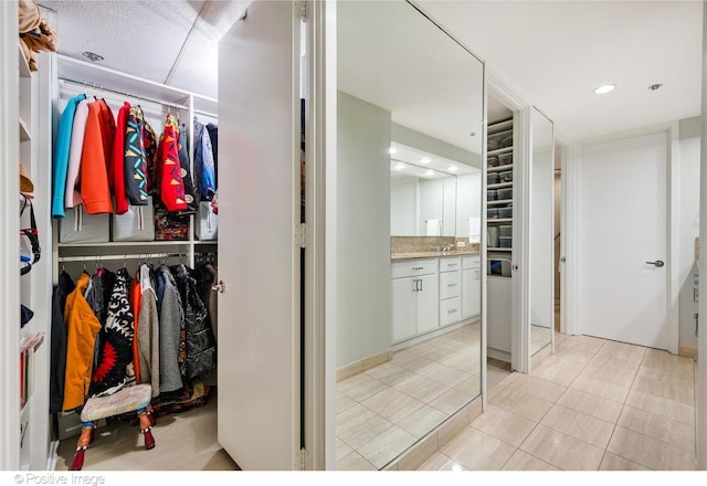950 N Michigan Ave Unit 2901, Chicago, IL 60611 - bathroom featuring vanity, tile patterned floors, a walk in closet, decorative backsplash, and recessed lighting