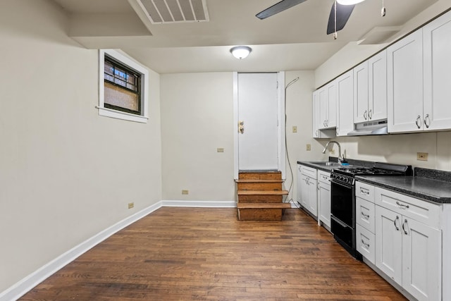 7035 N Sheridan Rd Unit G, Chicago, IL 60626 - kitchen with black range with gas stovetop, dark countertops, dark wood-type flooring, ceiling fan, and white cabinetry