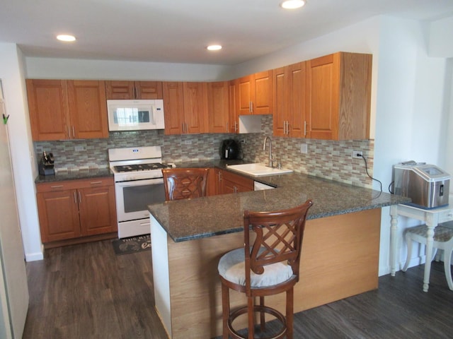 1819 Dunsford Ct, Schaumburg, IL 60194 - kitchen with white appliances, dark wood-style floors, a breakfast bar area, a peninsula, and recessed lighting