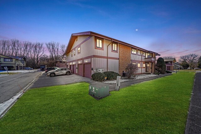 19400 Oak Ave Unit 1, Country Club Hills, IL 60478 - property exterior at dusk with a yard, an attached garage, and driveway