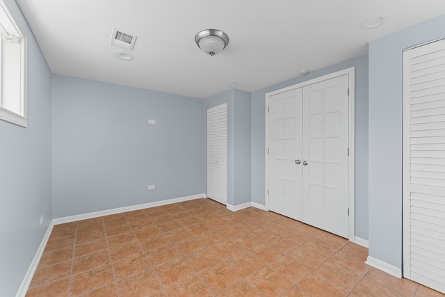 5008 Culver St, Skokie, IL 60077 - unfurnished bedroom with two closets and light tile patterned floors