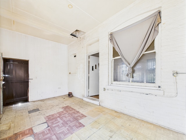 5045 W Erie St, Chicago, IL 60644 - unfurnished room featuring tile patterned floors and brick wall