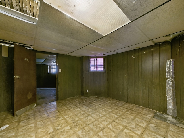 5045 W Erie St, Chicago, IL 60644 - basement featuring tile patterned floors, wooden walls, and a paneled ceiling
