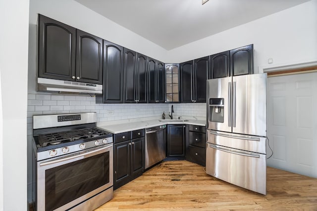 3722 S Wabash Ave, Chicago, IL 60653 - kitchen with appliances with stainless steel finishes, under cabinet range hood, light countertops, glass insert cabinets, and backsplash