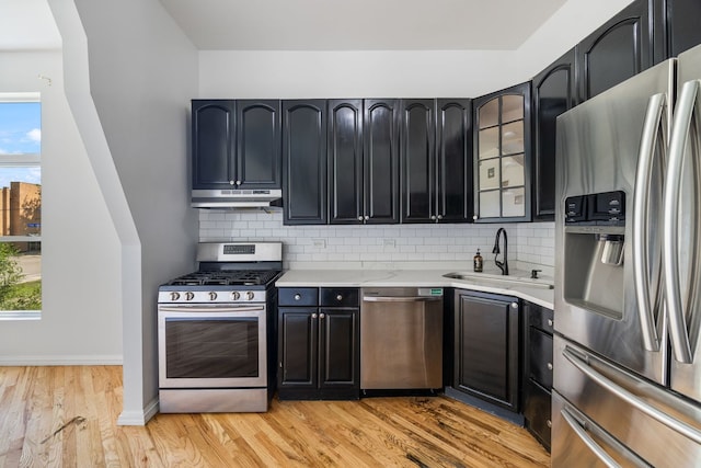 3722 S Wabash Ave, Chicago, IL 60653 - kitchen with appliances with stainless steel finishes, under cabinet range hood, light countertops, light wood-type flooring, and decorative backsplash