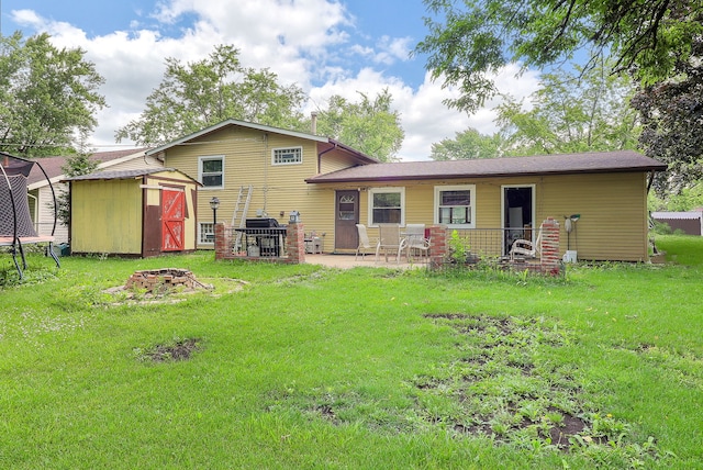 7936 N Ramsgate Cir, Hanover Park, IL 60133 - back of property with a shed, a trampoline, an outdoor fire pit, a patio, and a yard
