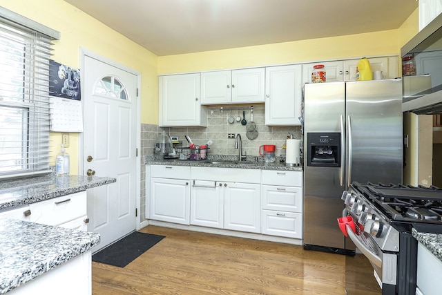 7936 N Ramsgate Cir, Hanover Park, IL 60133 - kitchen with appliances with stainless steel finishes, white cabinetry, light stone countertops, and backsplash