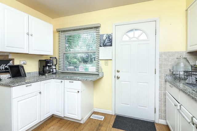 7936 N Ramsgate Cir, Hanover Park, IL 60133 - kitchen with light wood-style floors, white cabinets, stone counters, and tile walls
