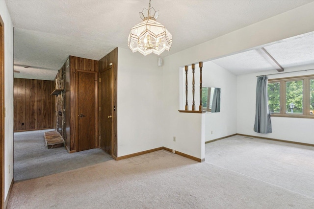 1619 Arnold Ave, Rockford, IL 61108 - carpeted empty room with a chandelier, lofted ceiling, wooden walls, and a textured ceiling