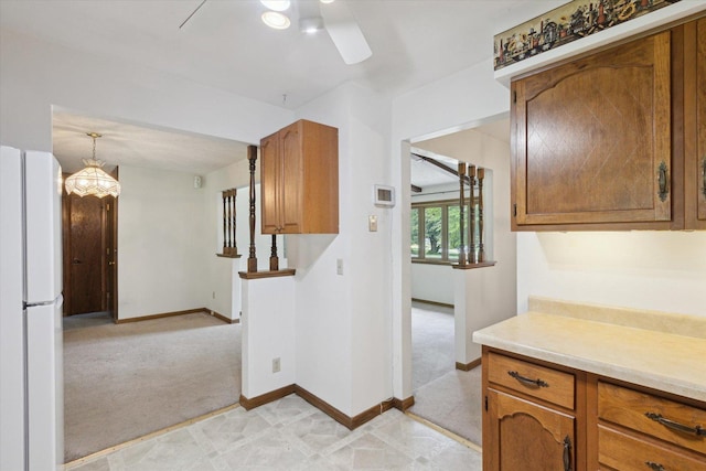 1619 Arnold Ave, Rockford, IL 61108 - kitchen featuring freestanding refrigerator, brown cabinetry, ceiling fan, light countertops, and light colored carpet