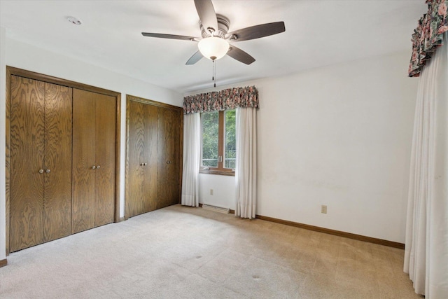 1619 Arnold Ave, Rockford, IL 61108 - unfurnished bedroom with multiple closets, light carpet, and ceiling fan