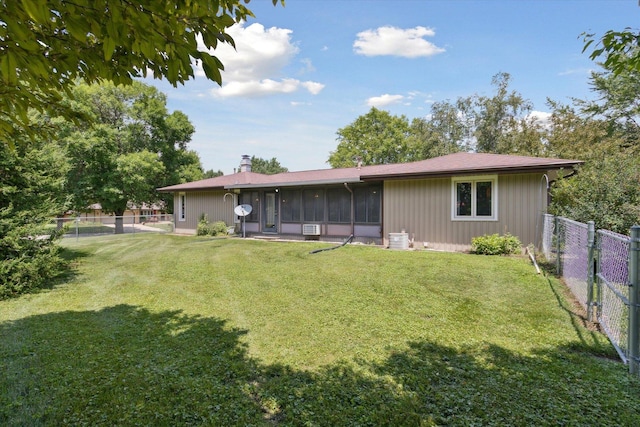 1619 Arnold Ave, Rockford, IL 61108 - back of property with a fenced backyard, a sunroom, and a chimney