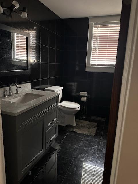 24 E 137th St, Riverdale, IL 60827 - bathroom with tile walls, vanity, tile patterned flooring, and backsplash