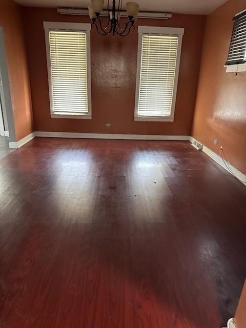 24 E 137th St, Riverdale, IL 60827 - unfurnished room featuring a chandelier, wood finished floors, and a wall mounted air conditioner