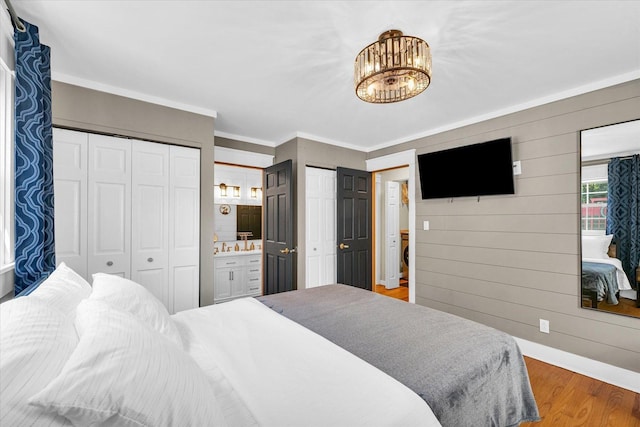 411 Hessel Blvd, Champaign, IL 61820 - bedroom with multiple closets, wood finished floors, a chandelier, crown molding, and ensuite bathroom