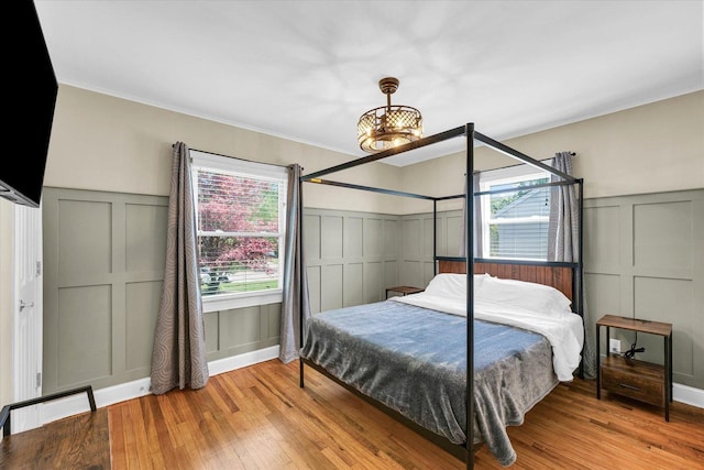 411 Hessel Blvd, Champaign, IL 61820 - bedroom with a decorative wall, wood-type flooring, multiple windows, wainscoting, and crown molding
