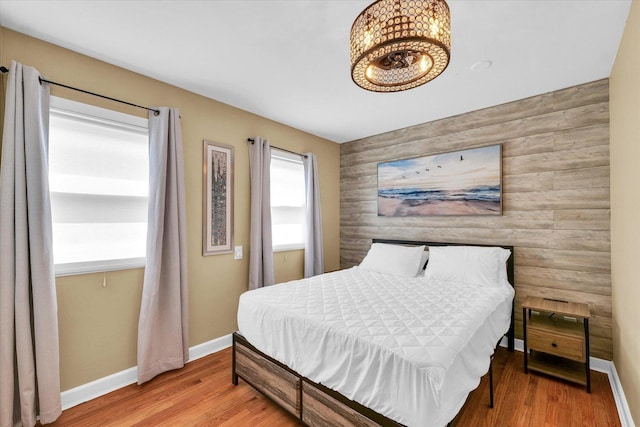 411 Hessel Blvd, Champaign, IL 61820 - bedroom featuring an accent wall, wood finished floors, and a chandelier