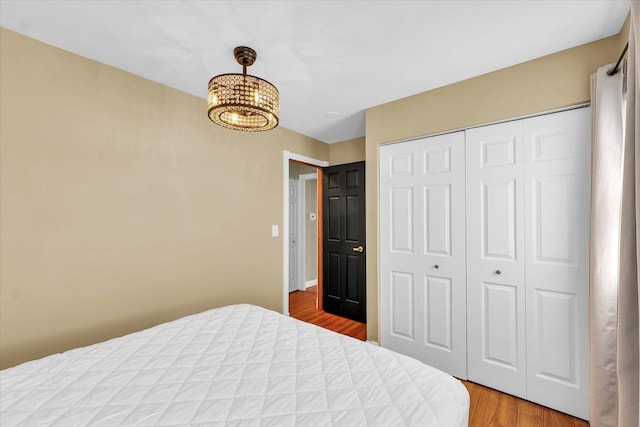 411 Hessel Blvd, Champaign, IL 61820 - bedroom with light wood-style flooring, a closet, and a chandelier
