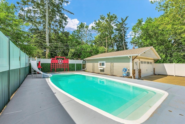 411 Hessel Blvd, Champaign, IL 61820 - view of swimming pool featuring a water slide, a fenced backyard, an outdoor structure, and view of wooded area