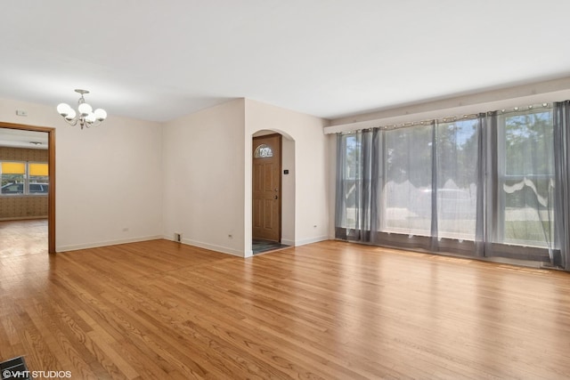 8024 W Charmaine Rd, Norridge, IL 60706 - unfurnished room with arched walkways, a chandelier, and wood finished floors