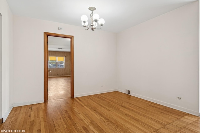 8024 W Charmaine Rd, Norridge, IL 60706 - empty room with a chandelier and light wood-style flooring