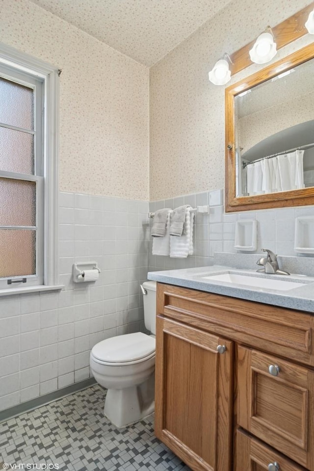 8024 W Charmaine Rd, Norridge, IL 60706 - bathroom featuring vanity, tile walls, a wainscoted wall, wallpapered walls, and tile patterned floors