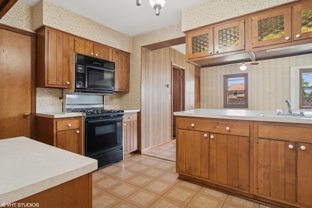 8024 W Charmaine Rd, Norridge, IL 60706 - kitchen with black appliances, wallpapered walls, brown cabinetry, light countertops, and light floors