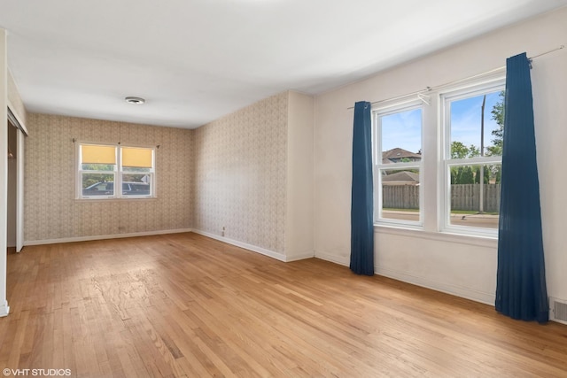 8024 W Charmaine Rd, Norridge, IL 60706 - unfurnished room with light wood finished floors, healthy amount of natural light, and wallpapered walls