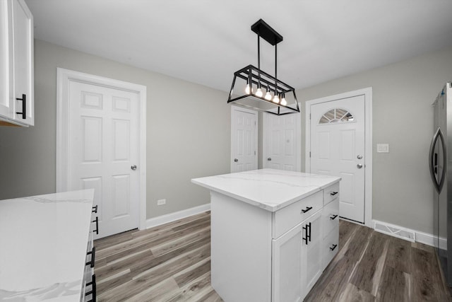 10823 S Ewing Ave, Chicago, IL 60617 - kitchen with light wood finished floors, white cabinetry, light stone countertops, and a kitchen island