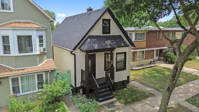 10823 S Ewing Ave, Chicago, IL 60617 - view of front facade featuring a shingled roof, a front yard, a chimney, and cooling unit