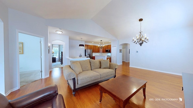 1114 Barkston Ln, Aurora, IL 60502 - living room featuring a chandelier, arched walkways, light wood-style flooring, and vaulted ceiling