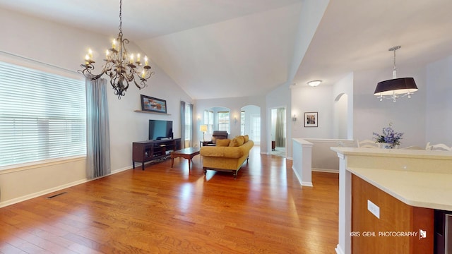 1114 Barkston Ln, Aurora, IL 60502 - living room with arched walkways, healthy amount of natural light, light wood-style floors, a chandelier, and lofted ceiling