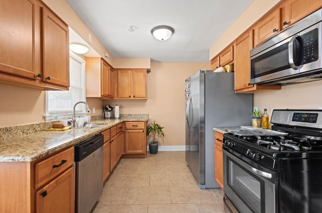 251 W 10th St, Chicago Heights, IL 60411 - kitchen with appliances with stainless steel finishes, light stone counters, light tile patterned flooring, and brown cabinetry