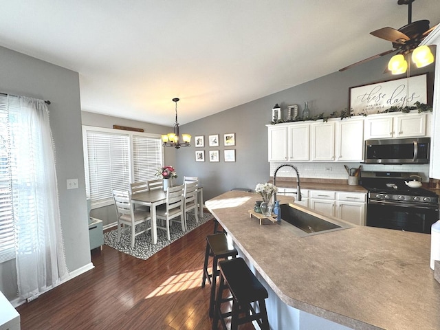1321 Acorn Dr, Crest Hill, IL 60403 - kitchen featuring stainless steel microwave, gas range, vaulted ceiling, a chandelier, and dark wood-type flooring