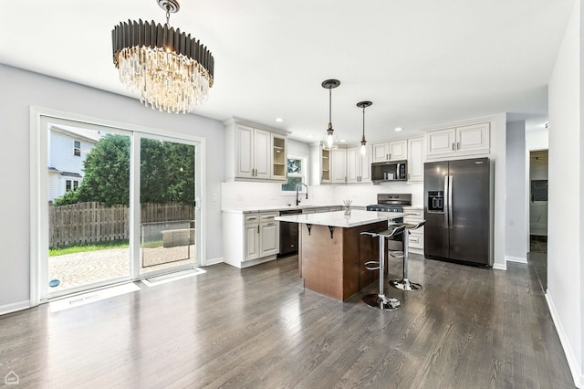 13636 Savanna Dr, Plainfield, IL 60544 - kitchen featuring stainless steel appliances, a breakfast bar, plenty of natural light, dark wood-style floors, and recessed lighting