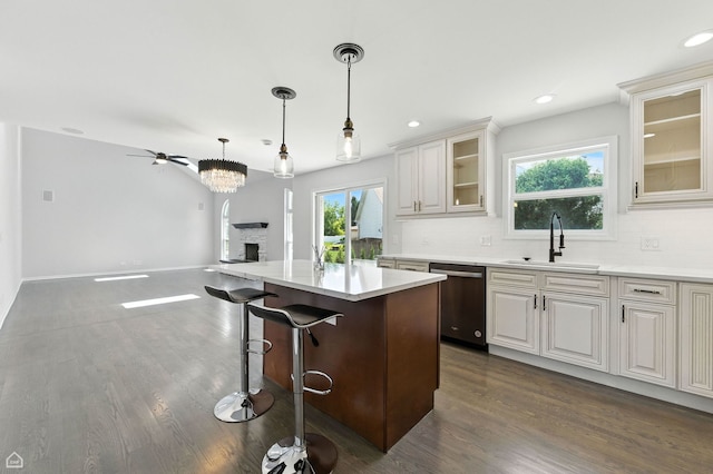 13636 Savanna Dr, Plainfield, IL 60544 - kitchen with stainless steel dishwasher, dark wood-style floors, light countertops, a breakfast bar area, and recessed lighting