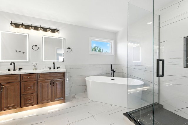 13636 Savanna Dr, Plainfield, IL 60544 - full bathroom with double vanity, a freestanding tub, a shower stall, tile walls, and marble look tiles