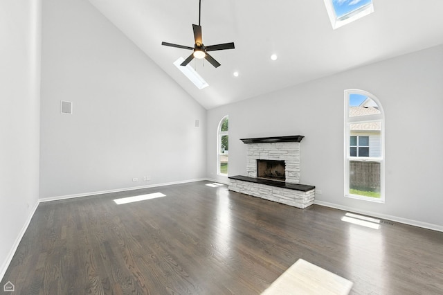 13636 Savanna Dr, Plainfield, IL 60544 - unfurnished living room with high vaulted ceiling, a skylight, plenty of natural light, a stone fireplace, and dark wood-style floors