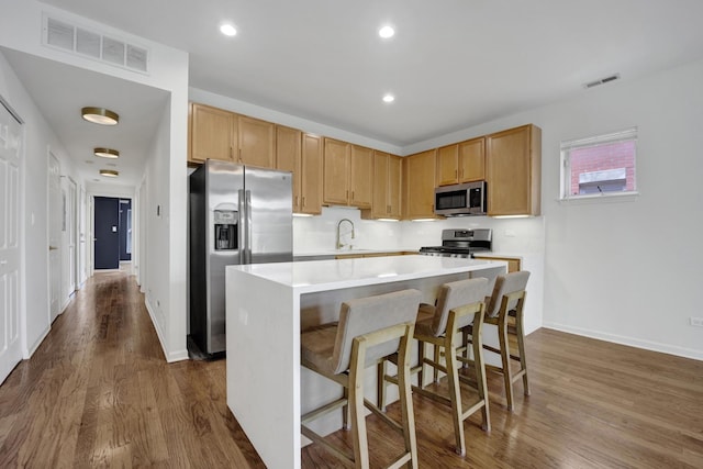 1414 S Halsted St Unit 3A, Chicago, IL 60607 - kitchen featuring stainless steel appliances, a center island, light countertops, dark wood-style flooring, and a kitchen breakfast bar