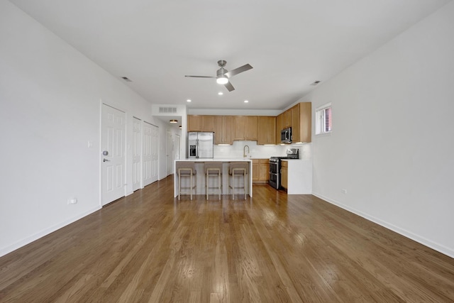 1414 S Halsted St Unit 3A, Chicago, IL 60607 - kitchen with appliances with stainless steel finishes, a ceiling fan, light countertops, dark wood finished floors, and a breakfast bar area