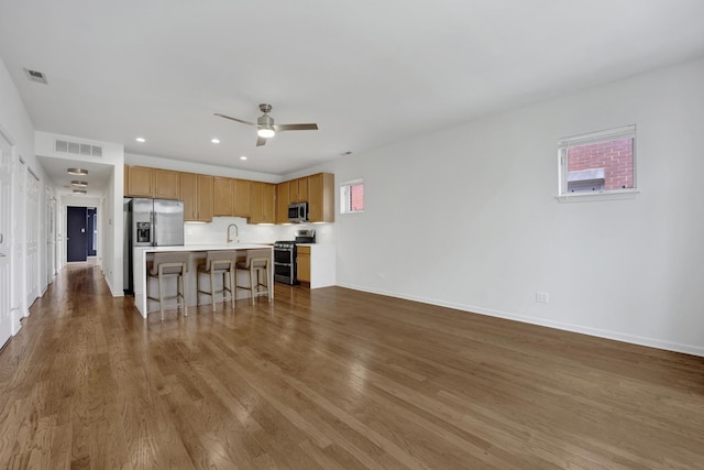 1414 S Halsted St Unit 3A, Chicago, IL 60607 - kitchen with stainless steel appliances, light countertops, a kitchen bar, wood finished floors, and recessed lighting
